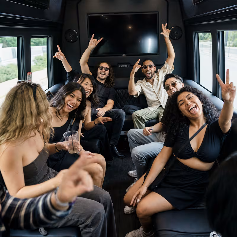 Group boarding a white charter bus for Concert Transportation transportation in Pittsburgh