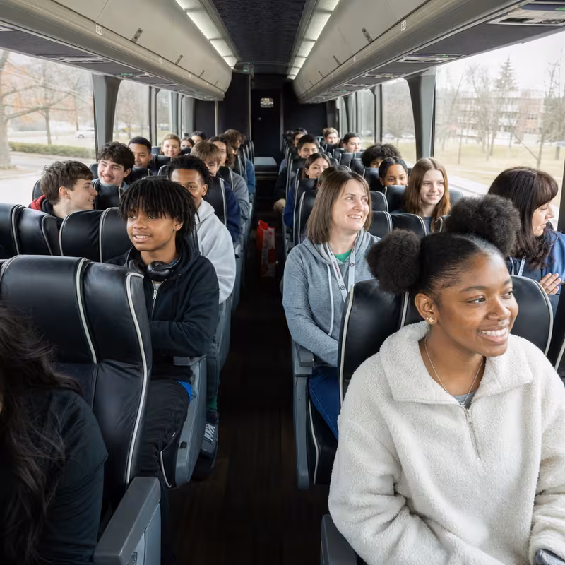 Group boarding a white charter bus for School Transportation transportation in Pittsburgh
