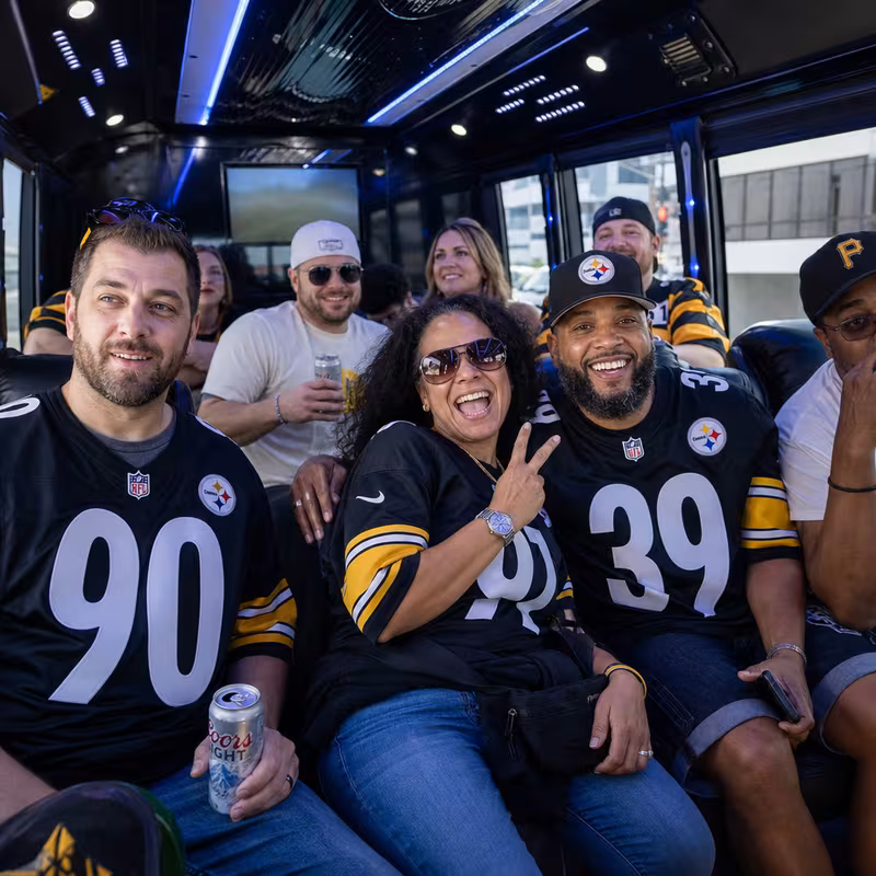 Group boarding a white charter bus for Sporting Event Transportation transportation in Pittsburgh